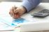 Foto: Person zeigt mit Stift auf Akten